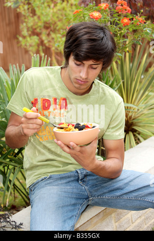 Young Man Eating Cornflakes with Berries Model Released Stock Photo