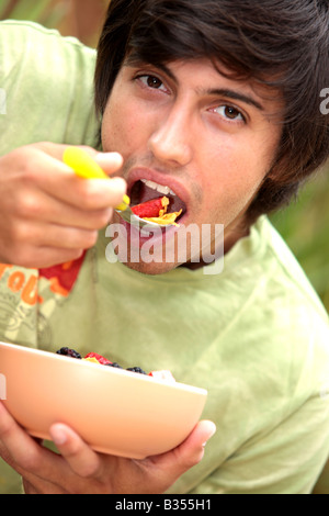 Young Man Eating Cornflakes with Berries Model Released Stock Photo