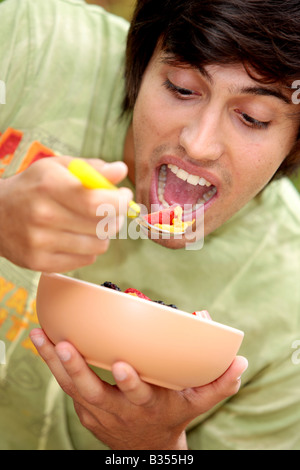 Young Man Eating Cornflakes with Berries Model Released Stock Photo