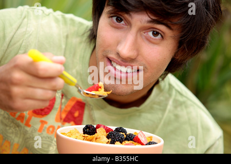 Young Man Eating Cornflakes with Berries Model Released Stock Photo