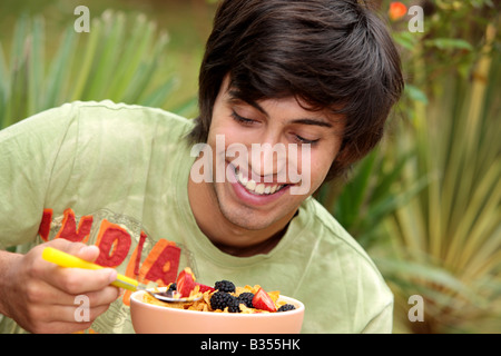 Young Man Eating Cornflakes with Berries Model Released Stock Photo