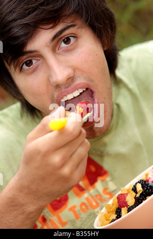 Young Man Eating Cornflakes with Berries Model Released Stock Photo