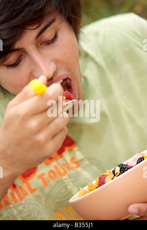 Young Man Eating Cornflakes with Berries Model Released Stock Photo