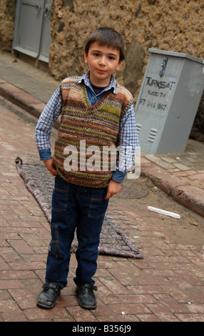 A young boy stands alone in the streets of the picturesque neighbourhood of Balat, Istanbul. Stock Photo