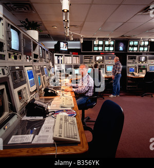 Men working at computer console in high tech telecommunications facility Stock Photo