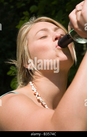 Young woman drinking from a wine bottle. UK. Stock Photo