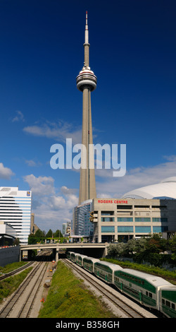 GO commuter train leaving Union Station downtown Toronto with CN tower and stadium in the evening after work Stock Photo