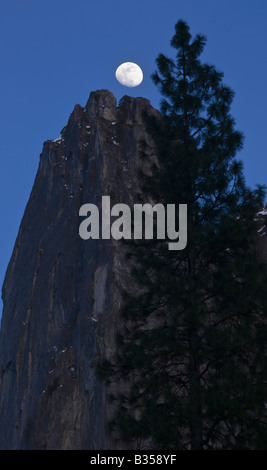 A nearly full moon rises over the top of Sentinel Spire Yosemite National Park California USA Stock Photo