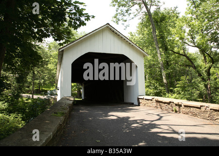 Loux Covered Bridge white wood with stone leading walls. Stock Photo