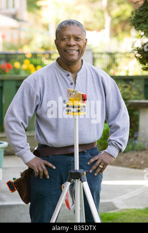 African American man using a laser level Stock Photo