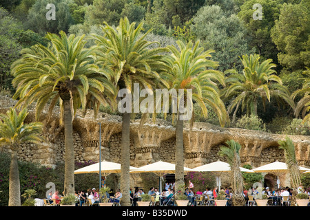 SPAIN Barcelona Parc Guell designed Antoni Gaudi architect Modernisme architecture people sit under palm trees near viaduct Stock Photo