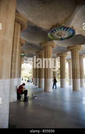 SPAIN Barcelona Man play guitar in Hall of 100 columns Parc Guell designed Antoni Gaudi architect Modernisme architecture Stock Photo