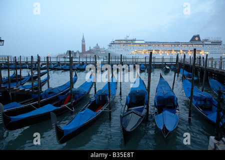 Gondolas and a passenger liner at dusk, Venice, Italy Stock Photo