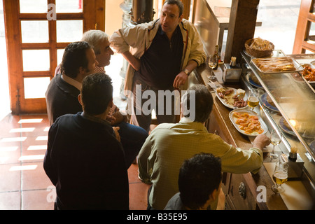 SPAIN Salamanca Interior of Casa de Tapas restaurant male customers stand at bar and sample tapas dishes Stock Photo