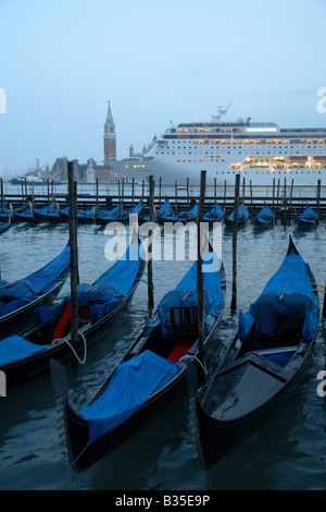 Gondolas and a passenger liner at dusk, Venice, Italy Stock Photo