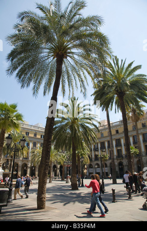 SPAIN Barcelona People walk past palm trees and fountain in Placa Reial Neoclassical square plaza Stock Photo