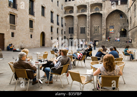 SPAIN Barcelona Couples sit at tables while female acoustic guitar playing in Placa del Rei plaza King s Square Stock Photo