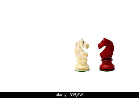 Wooden chess pieces facing each other, white background Stock Photo