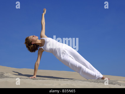Young woman practicing yoga in the side plank pose Stock Photo