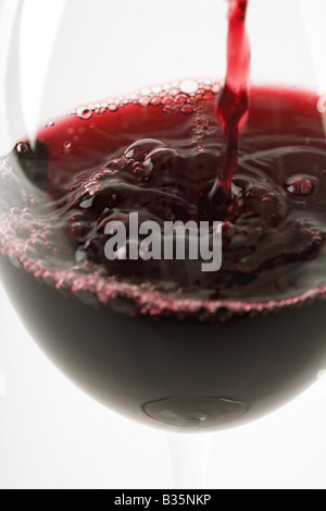 Red wine pouring into glass, close-up Stock Photo