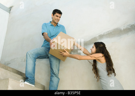 Father and daughter moving cardboard box together, low angle view Stock Photo