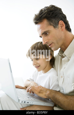 Father and son using laptop together Stock Photo