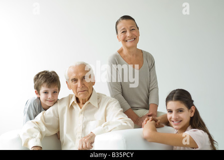 Grandparents sitting with grandchildren, all smiling, portrait Stock Photo