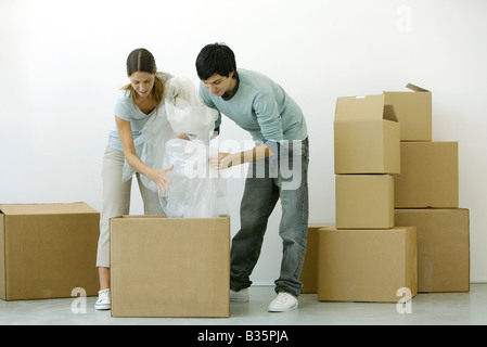 Couple unpacking cardboard boxes together Stock Photo