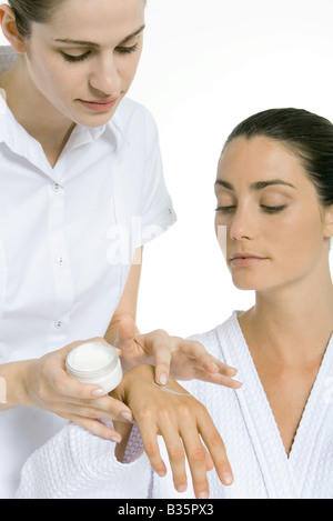 Beautician applying moisturizer to woman's hand Stock Photo