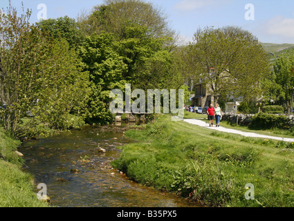 Couple out walking beside Malham Beck in the village of Malham, North Yorkshire Dales National Park, England. Stock Photo