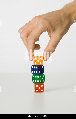 Hand stacking colorful dice, cropped view Stock Photo