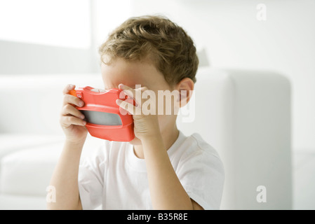 Little boy looking in toy view finder Stock Photo