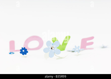 Paper flowers and letters spelling the word 'love' Stock Photo