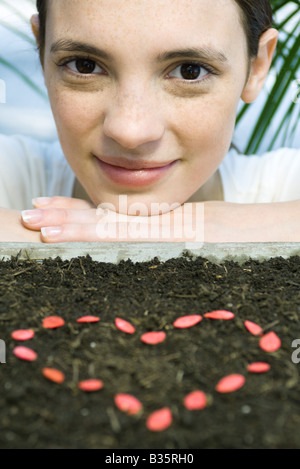 Young woman with seeds making heart shape Stock Photo