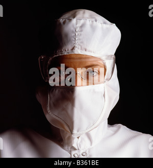 Female technician dressed in special low static outfit worn during the fabrication of micro computer chips Stock Photo