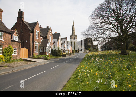 Astbury Cheshire England UK April The houses are set around the daffodil covered triangular village green in this lovely village Stock Photo