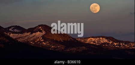 A full moon rises over the Ansel Adams Wilderness as seen from Sentinel Dome Yosemite National Park California USA Stock Photo