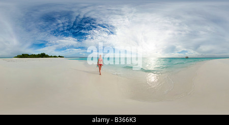 360 degree panoramic view of young woman walking along deserted white sand beach in Maldives near India Stock Photo