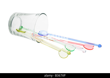 Color plastic swizzle sticks spilled from glass on white background Stock Photo