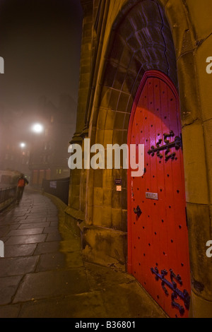 Red church door on Johnstone Terrace Edinburgh on a foggy night Stock Photo