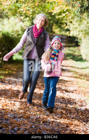 Grandmother and granddaughter running outdoors in park and smiling Stock Photo