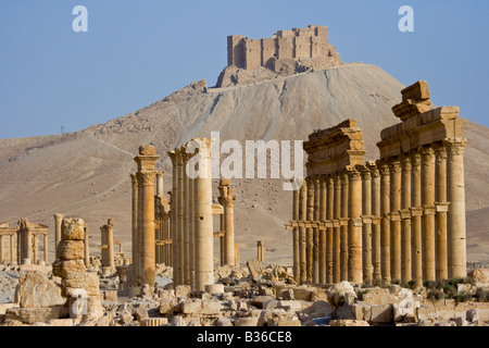 Ancient Collonade and Arab Castle Qalaat Ibn Maan at the Roman Ruins of Palmyra in Syria Stock Photo