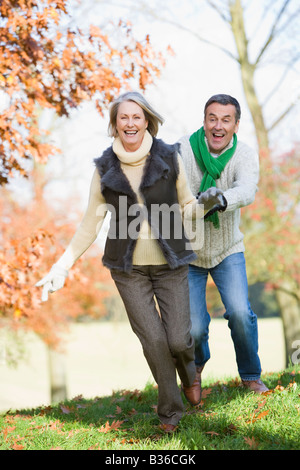 Senior couple outdoors running around and smiling (selective focus) Stock Photo