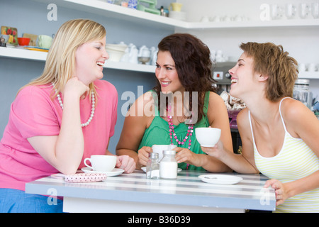 Three young woman sitting at a table and drinking tea Stock Photo