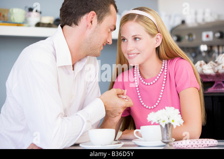 Young couple sitting at a table and having tea together Stock Photo