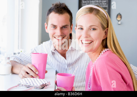 Young couple having a cold drink in a cafeteria Stock Photo