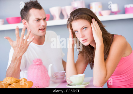 Young couple sitting at a table arguing Stock Photo