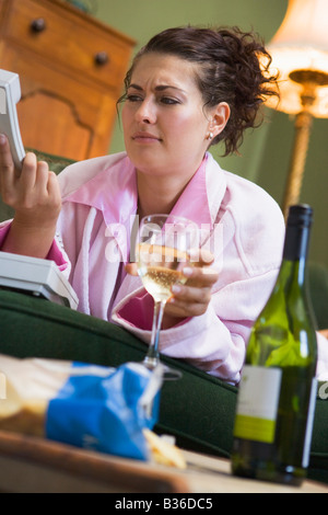 Annoyed young woman looking at telephone handset Stock Photo