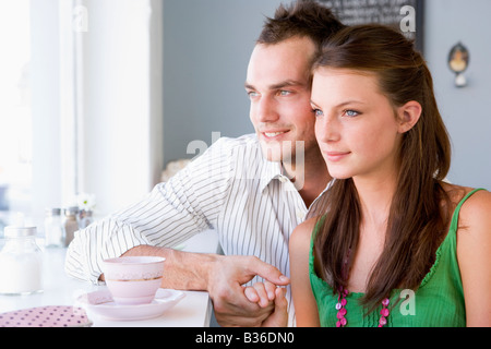 Young couple having a cold drink in a cafeteria Stock Photo