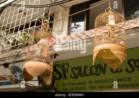 Bird cages hang above a shop front the old quarter Hanoi Vietnam Stock Photo